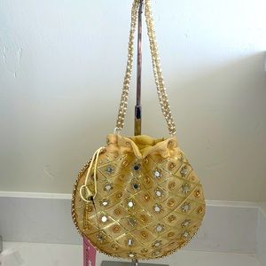 Small cream potli/drawstring bag with gold ethnic embroidery